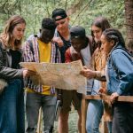 Group of adults reviewing a map outdoors to find a summer camp to rent