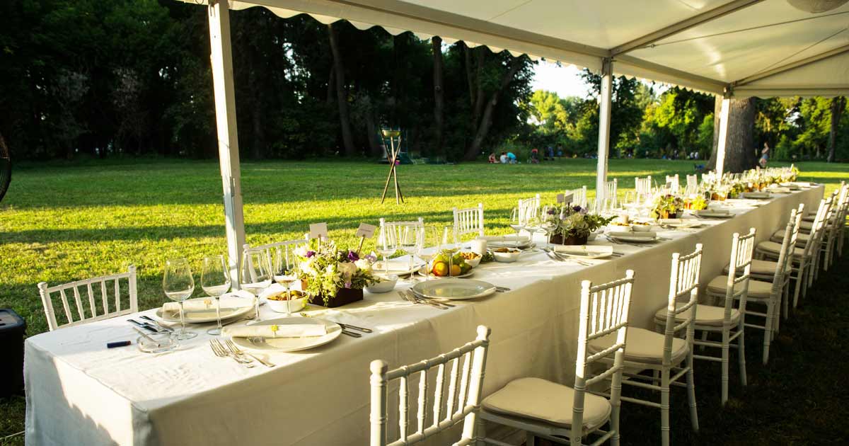 Outdoor dining tent set for a group meal at a summer camp family reunion
