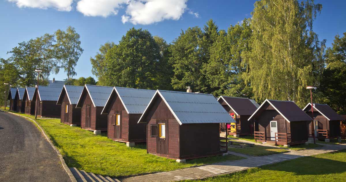 Row of summer camp cabins at a facility available for group rental pricing